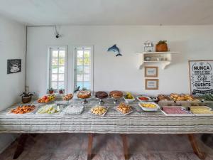 a table filled with lots of different types of food at Pousada Paraíso do Atlântico in Arraial do Cabo