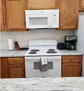 a kitchen with a white stove and a microwave at Tiny home rentals near Ft Moore in Phenix City