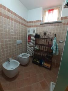 La salle de bains est pourvue de toilettes blanches et d'un lavabo. dans l'établissement Appartamento Stalle Lunghe, à Prato Nevoso
