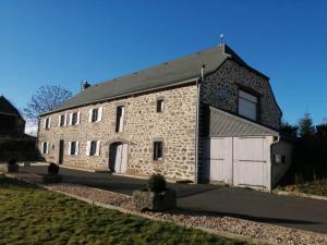 um grande edifício de tijolos com uma garagem branca em LA MAISON DES HIRONDELLES em Cussac