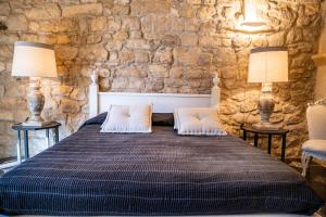 a bedroom with a bed with two lamps and two chairs at San Giorgio Palace Modica in Modica