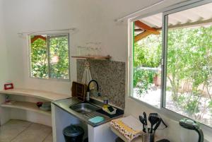 Una cocina con fregadero y dos ventanas. en Apartamentos GoPipa934, en Pipa