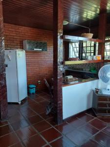 a kitchen with a white refrigerator and a brick wall at Flats Tartaruga Búzios in Búzios