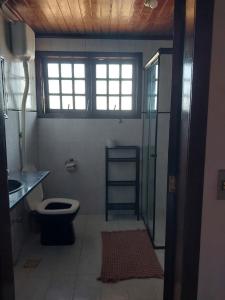 a bathroom with a toilet and a glass shower at Flats Tartaruga Búzios in Búzios