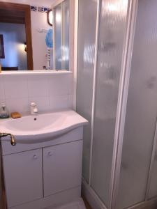 y baño blanco con lavabo y ducha. en Echappée Bleue Immobilier - Villa Les Pesquier, en Hyères