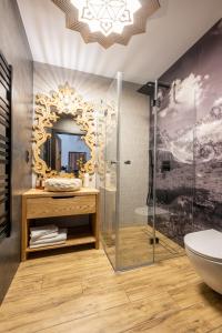 baño con espejo y lavabo en STACJA NOSAL Apartamenty, en Zakopane