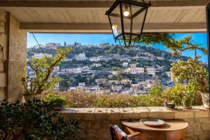 a patio with a table and a view of a city at San Giorgio Palace Modica in Modica
