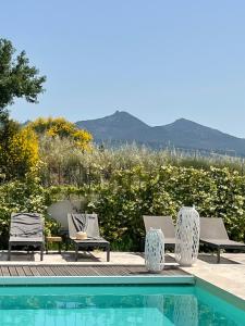 een zwembad met stoelen en uitzicht op de bergen bij Le Mas Saint Philippe in Jonquières