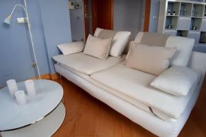 a white couch in a living room with a table at LUXEinBurgos Atico con Vistas Espectaculares in Burgos
