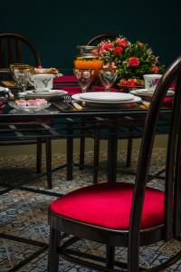a dining room table with a red chair and a red cushion at Palazzo Arone dei Baroni di Valentino in Palermo