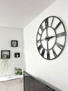 a large clock on a wall in a room at New Build Cosy Duplex Modern Apartment Greater Manchester in Stockport