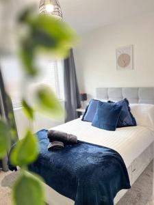 a bedroom with a bed with blue pillows at New Build Cosy Duplex Modern Apartment Greater Manchester in Stockport