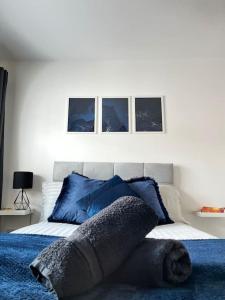 um quarto com uma cama com almofadas azuis em New Build Cosy Duplex Modern Apartment Greater Manchester em Stockport