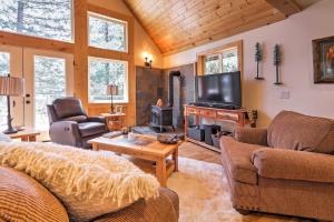 ein Wohnzimmer mit Sofas, einem TV und einem Kamin in der Unterkunft Rustic Retreat with Deck Steps From Lake Almanor! in Lake Almanor