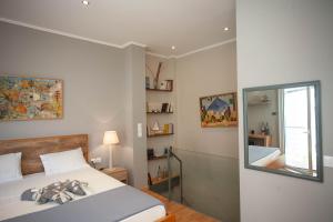 una camera da letto con un letto con specchio e una finestra di Euzoia luxury maisonette a Chania