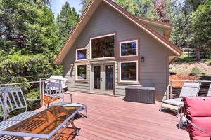 una terraza de madera con sillas y una casa en Rustic Retreat with Deck Steps From Lake Almanor!, en Lake Almanor