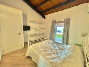 a bedroom with a white bed and a window at Domu Virginia in Castiadas