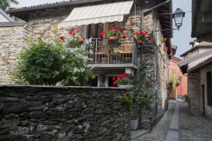 メルゴッツォにあるRustico Giorgiaのバルコニーに花の咲く石造りの建物