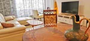 uma sala de estar com uma mesa e uma televisão em Large apartment with sea view em Bat Yam