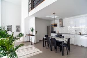 a kitchen with white cabinets and a table and chairs at Loft Valterna 9 in Paterna