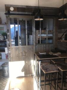 eine Küche mit einer Theke und Hockern in einem Zimmer in der Unterkunft Studio montagnard vue splendide ALPE D HUEZ LES PASSEAUX in Huez