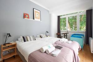 Un dormitorio con dos camas con toallas encima. en 1 min to the beach - perfect for 6 guests, en Carcavelos