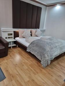um quarto com uma cama grande e uma cadeira em Haiminger Hof em Haiming