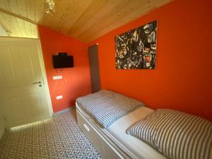 a bedroom with an orange wall with a bed in it at Villa Vrachos - uriges Steinhaus - in Vráchos