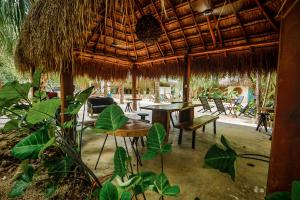 - un restaurant avec une table, des chaises et un parasol dans l'établissement Totem Buenavista, à Bacalar
