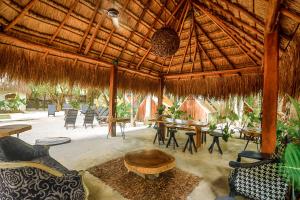 ein großer Pavillon mit Tischen und Stühlen und einem Tisch in der Unterkunft Sanctuary Bacalar in Bacalar