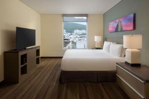 um quarto de hotel com uma cama e uma televisão de ecrã plano em Hyatt House Monterrey Valle San Pedro em Monterrey