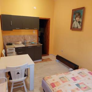 a small kitchen with a table and a bed at Apartman Lara in Kruševac