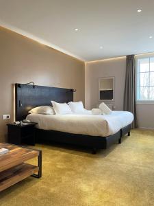 a large bedroom with a large bed and a table at Le Grand Hôtel Le Touquet-Paris-Plage in Le Touquet-Paris-Plage