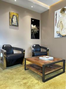 a living room with two chairs and a coffee table at Le Grand Hôtel Le Touquet-Paris-Plage in Le Touquet-Paris-Plage