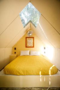 a bedroom with a yellow bed in an attic at Totem Buenavista in Bacalar