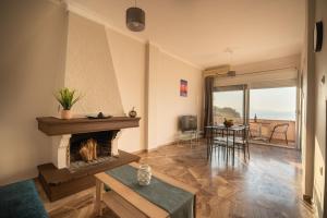 salon z kominkiem i widokiem na ocean w obiekcie Sea Gem w Chanii