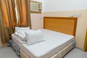 a bed with white sheets and pillows in a room at Arabian Sands Hotel فندق الرمال العربية in Haymāʼ