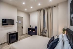 1 dormitorio con 1 cama y TV de pantalla plana en Tacito 23 Luxury rooms en Roma