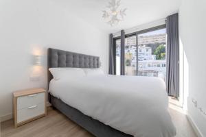 um quarto com uma cama grande e uma janela grande em CT 209 - Navigolf Penthouse - La Cala de Mijas em La Cala de Mijas