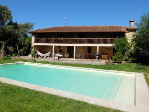 a house with a swimming pool in front of a house at Casas da Azenha do Rio in Barreiros