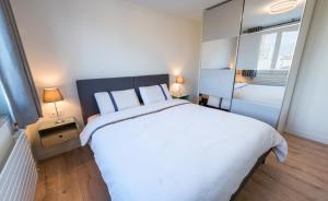 a bedroom with a large white bed and a mirror at T2 de standing, hôpitaux Montchat in Bron
