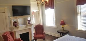 a bedroom with a fireplace and a chair and a television at The Mayor's Mansion Inn in Chattanooga