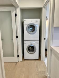 a laundry room with a washing machine and a washer at Oceanfront Fully Remodeled 2BR 2BA, Pool, Hot Tub, Gated Parking in Solana Beach