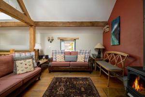 - un salon avec un canapé et une cheminée dans l'établissement The Hay Barn, à York