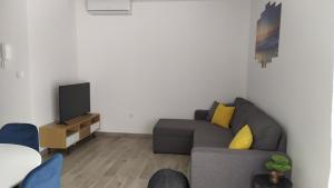 een woonkamer met een bank en een tv bij Urban Apartment Vukić in Trogir