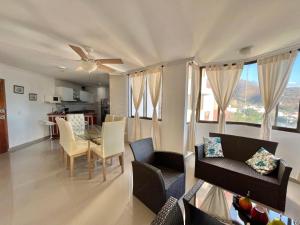 sala de estar con mesa y sillas y cocina en Perla del Caribe, en Santa Marta