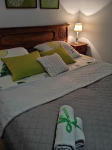 - un lit avec des oreillers verts et blancs dans l'établissement Nad Strumykiem, à Mszana Dolna