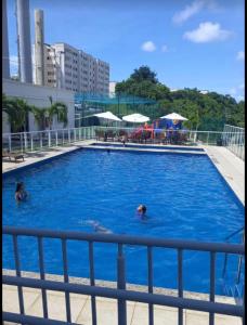 2 personas nadando en una gran piscina azul en Jardim da Costa perto da Praia e UFPB, en João Pessoa
