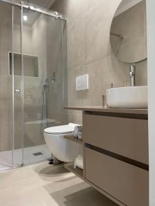 a bathroom with a toilet and a sink and a shower at Casa Fermar in Esposende