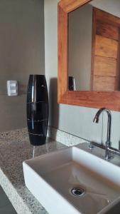 eine Küchentheke mit einem Waschbecken und einem Spiegel in der Unterkunft Aldeia Biribiri - Pousada in Caraíva